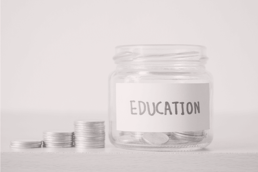 A glass jar with the word 'education' written on the front, filled with money